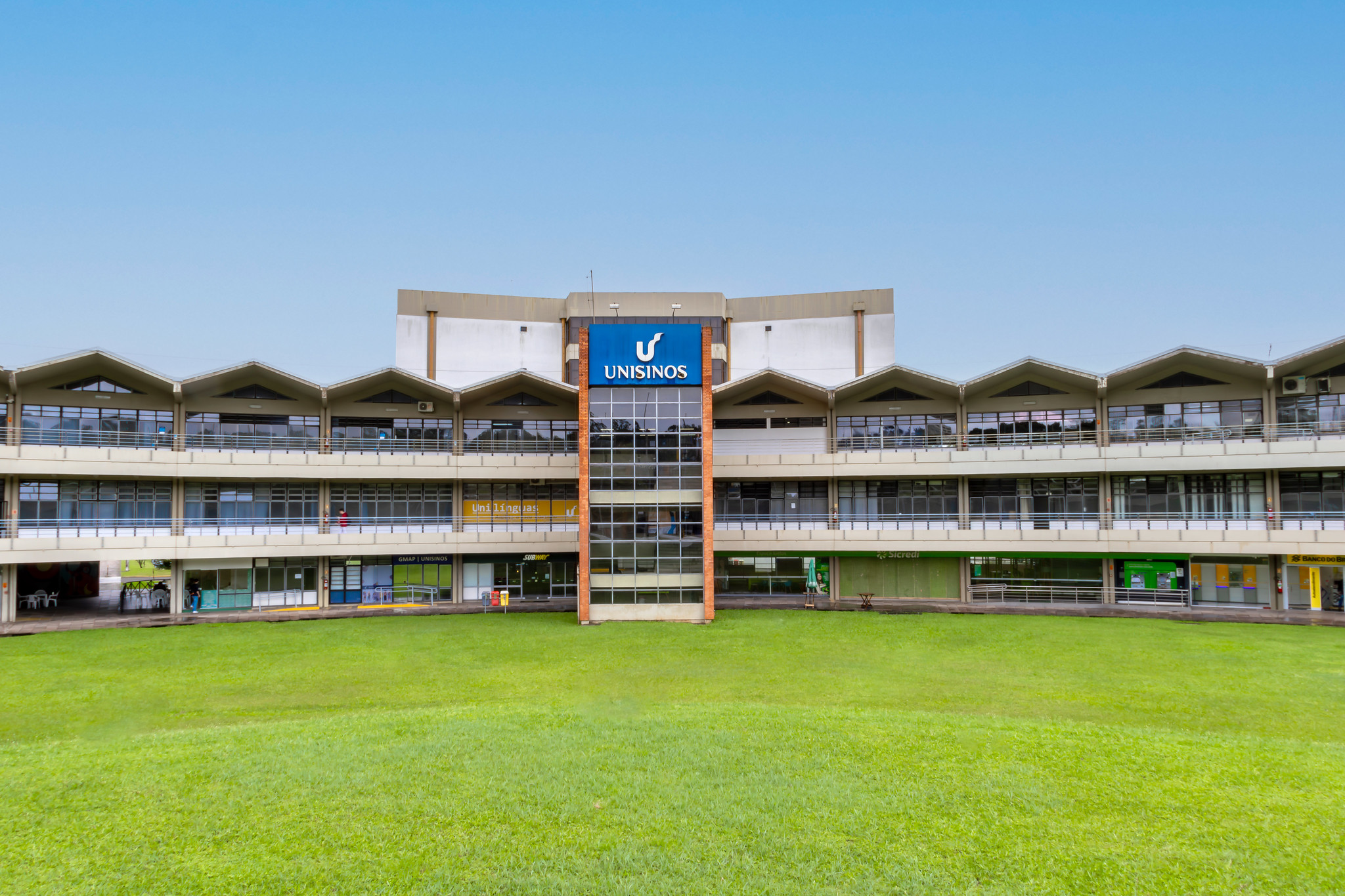 Imagem do prédio administrativo da Unisinos, com uma torre com o logo da universidade ao centro.