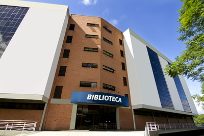 Faixada do prédio principal da biblioteca Unisinos, com letreiro azul escrito em branco Biblioteca.